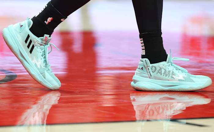 View of teal and black adidas shoes.